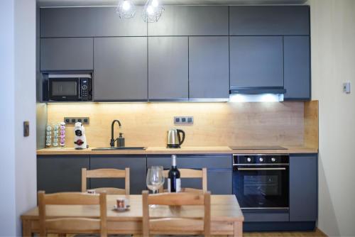 a kitchen with blue cabinets and a table and chairs at Apartmán na Hůrce in Horní Planá