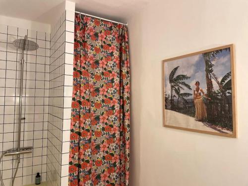 - un rideau de douche avec un motif floral dans la salle de bains dans l'établissement 8AUB - Superbe cosy appartement à deux pas du vieux port, à Marseille