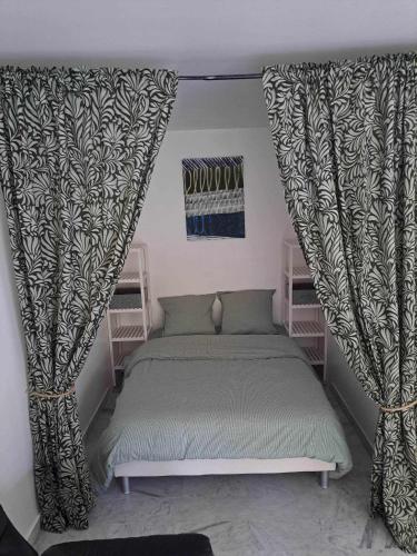 - une chambre avec un lit et des rideaux dans l'établissement Appartement calme, cosy Piscine, à Mandelieu-la-Napoule