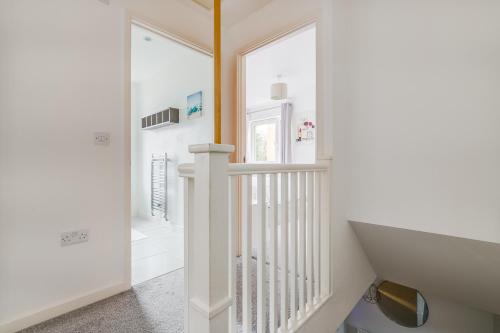 a white staircase in a home with a window at 3 bedroom detached house free car park close to town airport in Luton