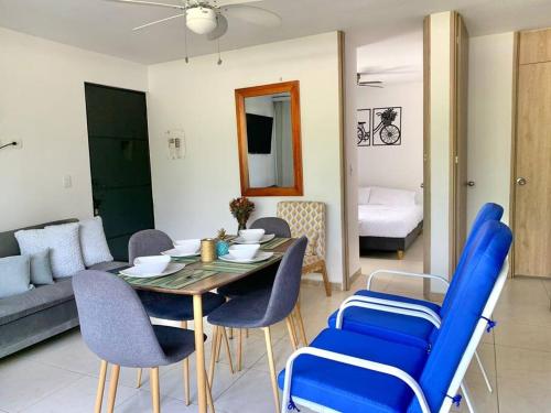 a living room with a table and blue chairs at Apartamento Eje Cafetero Parque del Café in La Tebaida