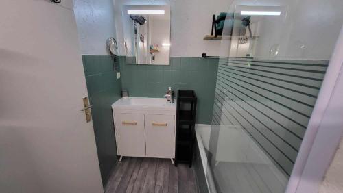 une petite salle de bain avec un lavabo et un miroir dans l'établissement Appartement calme, cosy Piscine, à Mandelieu-la-Napoule
