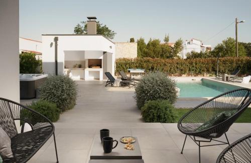 a patio with chairs and a swimming pool at Villa Zen near Medulin for 8 people with wellness & sea view - only 1 km from beach in Vintijan