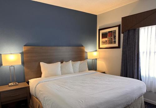 a large bed in a hotel room with two lamps at Baymont by Wyndham Indianapolis Northwest in Indianapolis