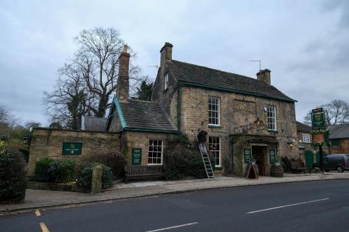 an old brick building on the side of a street at Rockingham Arms By Greene King Inns in Wentworth