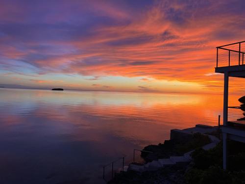 a sunset over a body of water at Touch of Class Cottage home in Savannah Sound