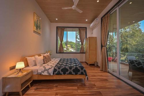 a bedroom with a bed and a large window at Elegant Villa By Tropicana Stays in Lonavala