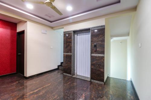 an empty room with a door and a red wall at Capital O N R Residency in Bengaluru