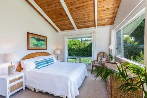 ein Schlafzimmer mit einem Bett und einem großen Fenster in der Unterkunft Hanalei Hideaway home in Hanalei
