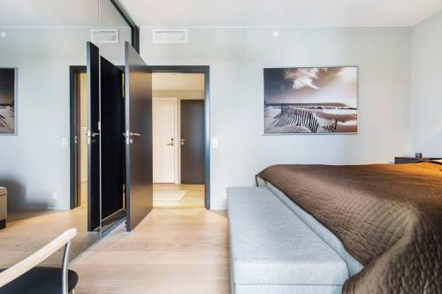 a bedroom with a bed and a sliding glass door at Super Central Designer Penthouse at 19th floor with Amazing View! in Oslo