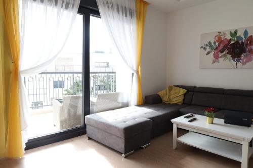 a living room with a couch and a large window at Trebinje Lux Apartment in Trebinje
