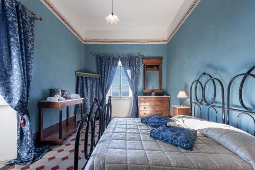 Un dormitorio con una cama con paredes azules y una ventana en Villa Il Frassine, en Rignano sullʼArno