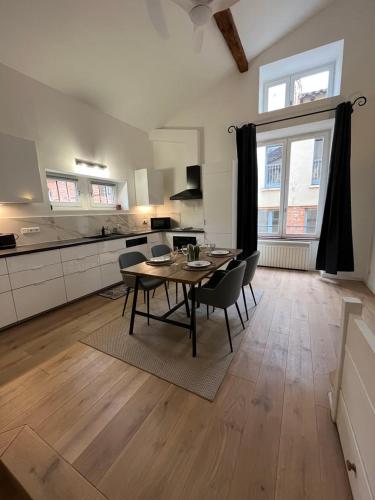 une cuisine et une salle à manger avec une table et des chaises dans l'établissement Saint-Rome - Capitole - Climatisation - Rénové, à Toulouse