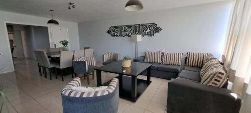 ein Wohnzimmer mit Sofa, Tisch und Stühlen in der Unterkunft Aconcagua Top in Mendoza