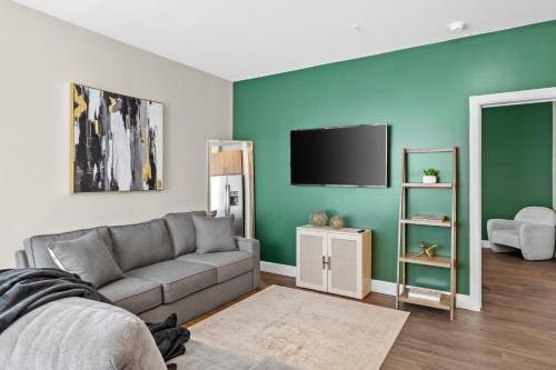 a living room with a couch and a flat screen tv at The Rodeo Drive Suite Penthouse The Gulch in Nashville