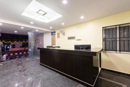 a lobby of a hair salon with a counter at Capital O Regal suites in Bengaluru