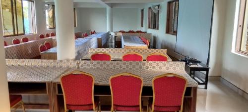 a dining room with red chairs and a table at DISCOVERY COURTS HOTEL in Entebbe