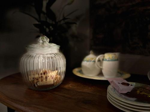 a glass jar on a table with plates and cups at Erbe12 loft&park historic apartment centro città in Genova