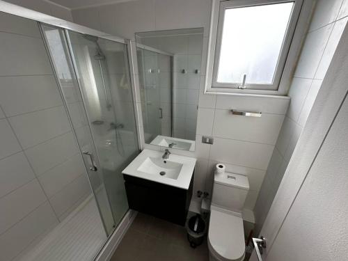 a bathroom with a toilet and a sink and a shower at Departamento in Talca