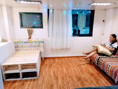 a woman sitting on a couch in a living room at Private Homestay 402 Lily's house 2 beds in city center in Ho Chi Minh City