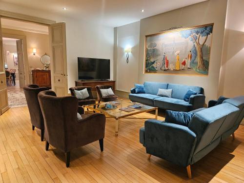 sala de estar con sofás azules y TV en Propriété standing Loire Valley en Luynes