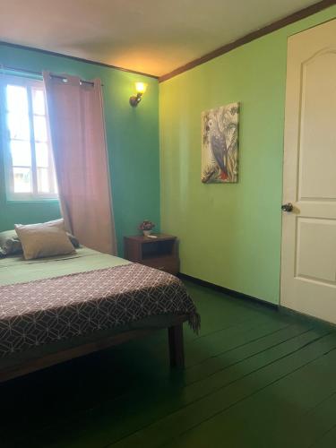 a bedroom with a bed and a window and a door at Hostal Cay in Bastimentos
