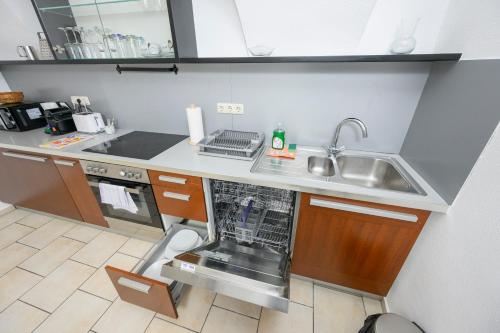 a small kitchen with a sink and a dishwasher at City Center Mödling in Mödling