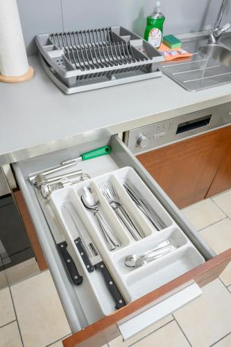 an open kitchen drawer with utensils in it at City Center Mödling in Mödling