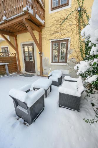 a patio covered in snow with tables and chairs at City Center Mödling in Mödling