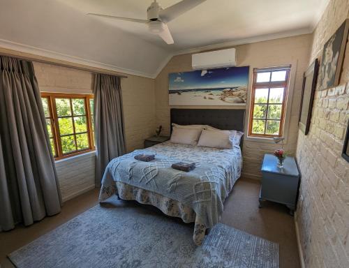 Un dormitorio con una cama y dos ventanas. en 33 Longifolia, en Stellenbosch