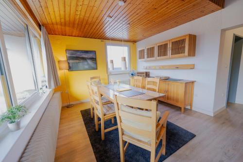 a dining room with a table and chairs at Ferienhaus Schöne Aussicht Ferienwohnung Gelb in Hemfurth-Edersee