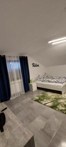 een slaapkamer met een bed in een kamer met blauwe gordijnen bij FeWo3&Frisch renovierte Wohnung mit Balkon in Bad Wurzach