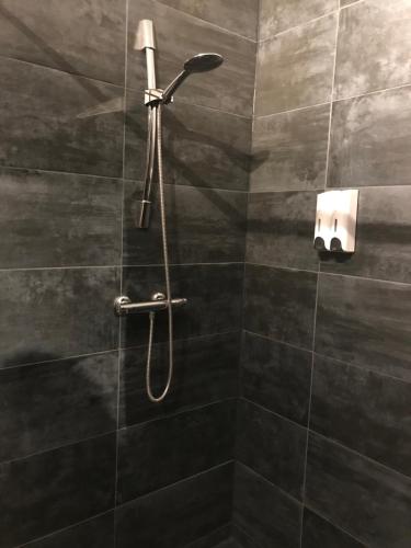 een douche met een douchekop in de badkamer bij De Rietnymf in Munnekeburen