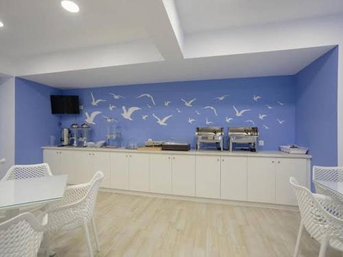 a room with a blue wall with birds on the wall at Mary Elen Boutique Hotel in Argassi