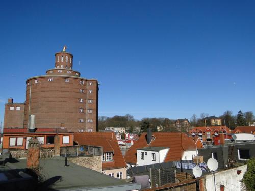 a large brick building with a tower on top of roofs at Über dem Kattsund in Eckernförde