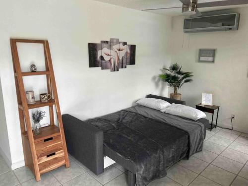 1 dormitorio con cama y estante de madera en Studio21-B Centric Comfort House, en Bayamón