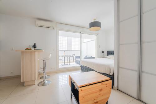 une chambre avec un lit, un bureau et une fenêtre dans l'établissement Joli studio centre Cannes, à Cannes