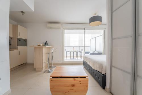 a bedroom with a bed and a kitchen with a table at Joli studio centre Cannes in Cannes
