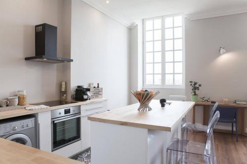 - une cuisine avec un comptoir et une cuisinière four supérieur dans l'établissement 60m² - Plein Centre - Vue Quais & Miroir d'eau, à Bordeaux