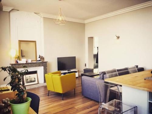 un salon avec un canapé et une chaise jaune dans l'établissement 60m² - Plein Centre - Vue Quais & Miroir d'eau, à Bordeaux
