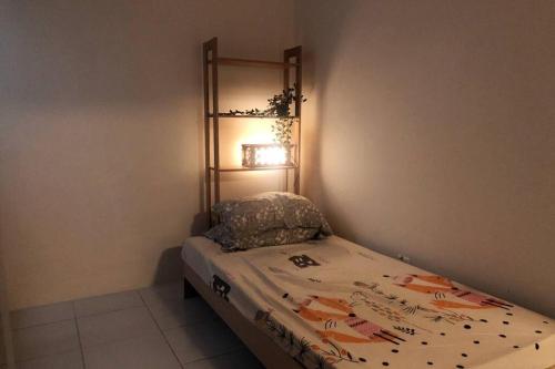 Dormitorio pequeño con cama con lámpara en la pared en Kita Bayu Townhouse, en Kampung Dengkil