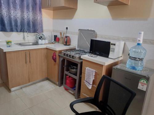 Una pequeña cocina con estufa y microondas. en City view suits, en Nairobi