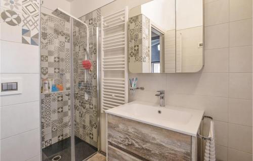 uma casa de banho com um lavatório e um chuveiro com um espelho. em 3 Bedroom Pet Friendly Home In Solarino em Solarino