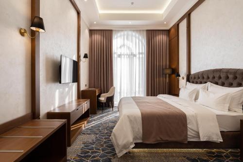 a hotel room with a bed and a television at FrankFort Expo Hotel in Tashkent