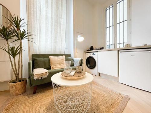 - un salon avec un canapé vert et un lave-linge dans l'établissement Maison Berno, à Beausoleil