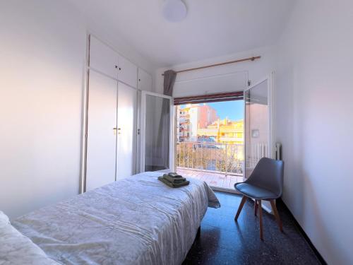 a bedroom with a bed and a chair and a window at Caserna 13 - Luminoso Piso en Figueres in Figueres