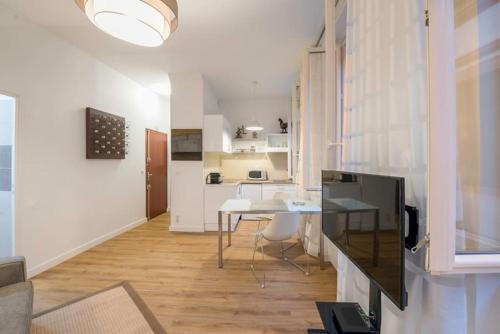 ein Wohnzimmer mit einem Tisch und einer Küche in der Unterkunft Saint-Aubin - Centre-ville - Calme - Confortable in Toulouse