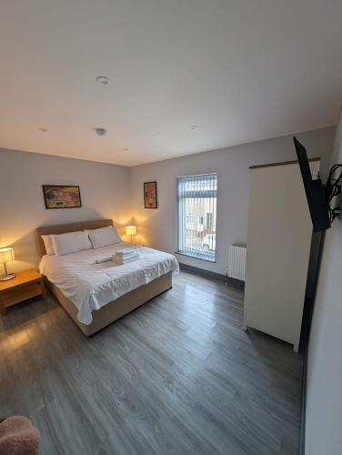 a bedroom with a bed and a large window at Sussex Apartments 26B in Grimsby