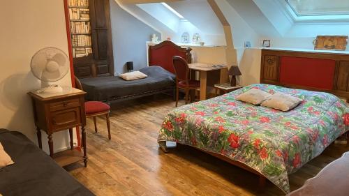 a bedroom with a bed and a chair and a table at Caux-Breizh in Rohan