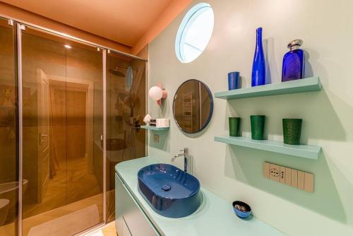 a bathroom with a blue sink and a shower at Verde Acqua - Design & Comfort in Milan